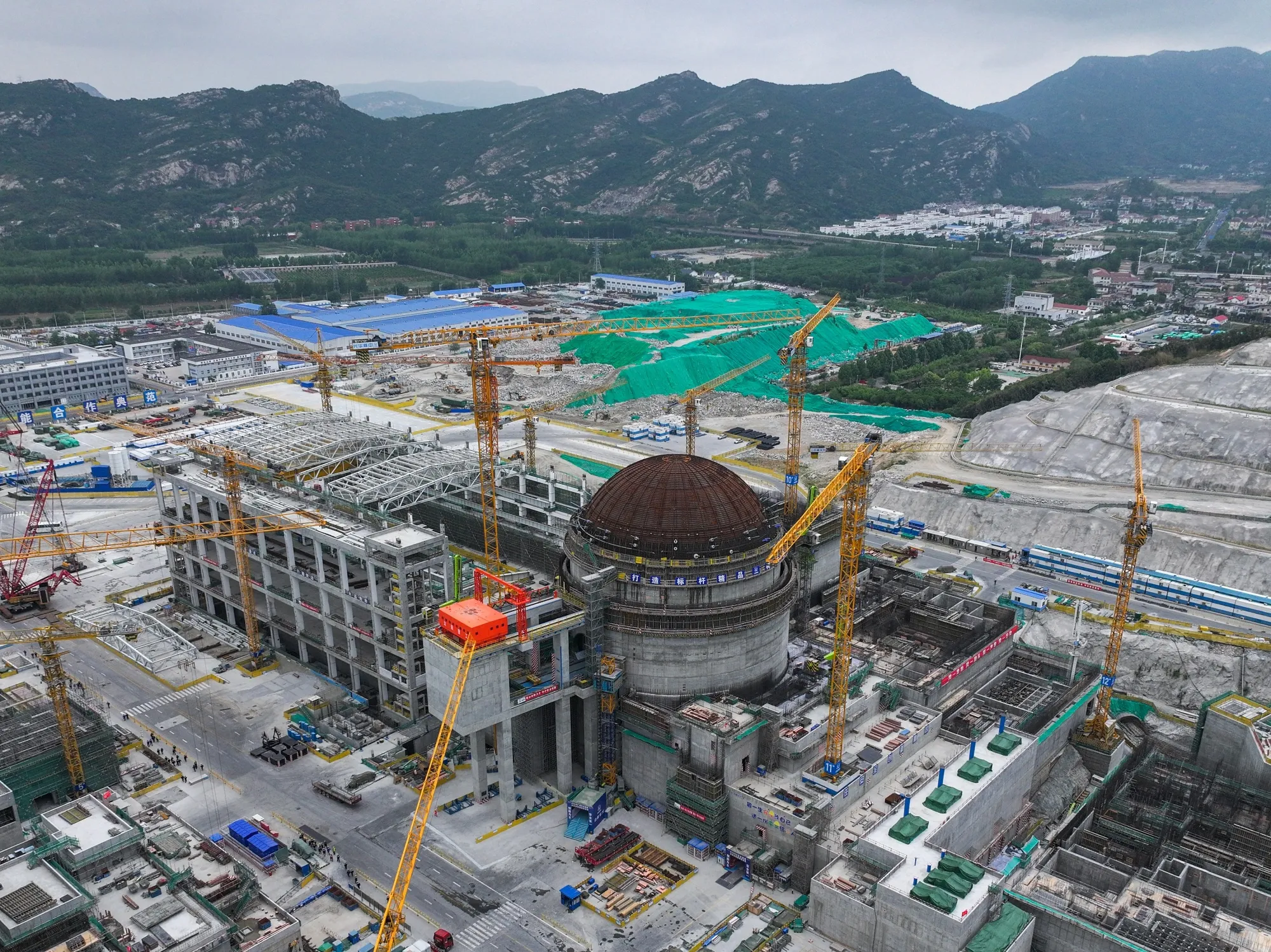 Nuclear reactor under construction in China, containment dome and tower cranes